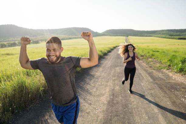 istock Young man running with female friend and winning 1276453500