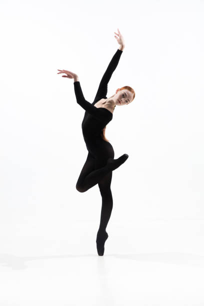 istock Young and graceful ballet dancer in minimal black style isolated on white studio background 1276455008