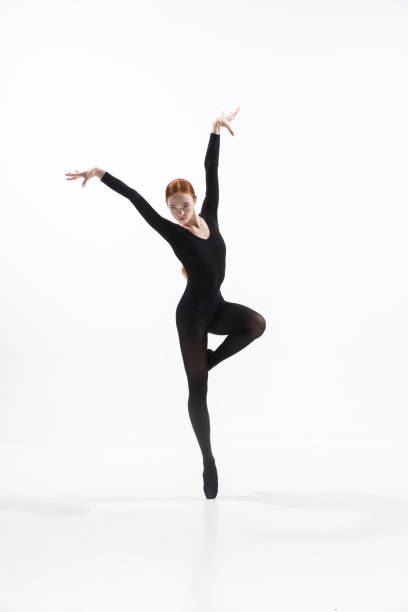 istock Young and graceful ballet dancer in minimal black style isolated on white studio background 1276455105
