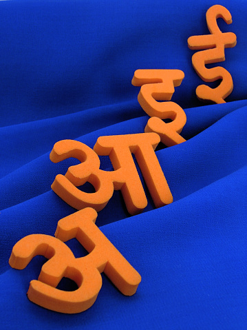 A image showing starting 4 alphabets of Indian Hindi language on blue cloth background giving high contrast to the letters