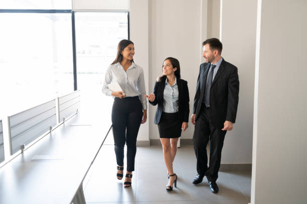 istock Business team walking and talking in office 1276457303