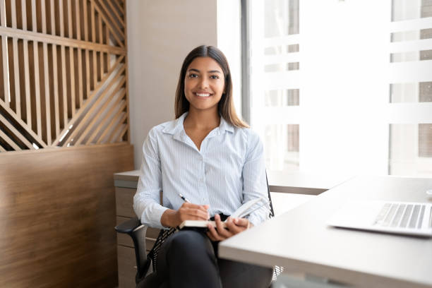 confident young businesswoman at work - business looking at camera office new imagens e fotografias de stock