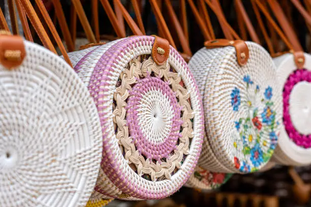 Photo of Famous Balinese rattan eco bags in a local souvenir market on street in Ubud, Bali, Indonesia. Handicrafts and souvenir shop display