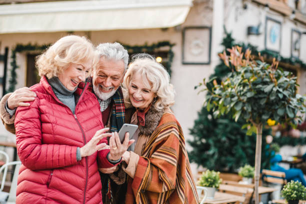 istock Senior friends using mobile phone on the street 1276459270