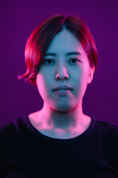 portret młodej kobiety oświetlonej neonowymi kolorowymi światłami - vertical bright brightly lit vibrant color zdjęcia i obrazy z banku zdjęć