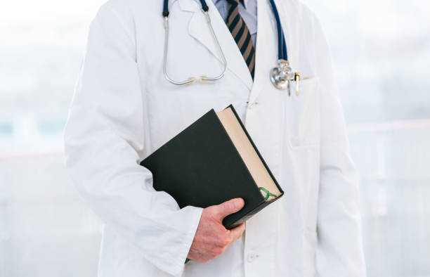 Doctor holding a medical textbook stock photo