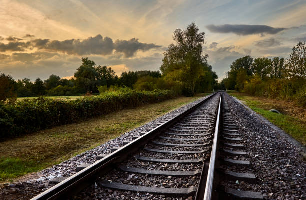 istock Rails in countryside in front of cloudy sky with sunset 1276464729