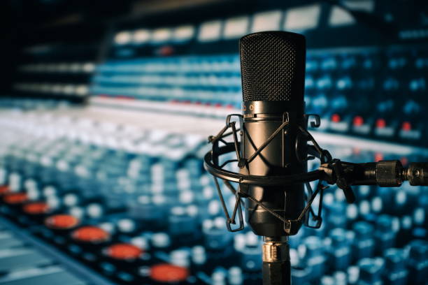 istock Condenser microphone with mixing desk in the background 1276465784