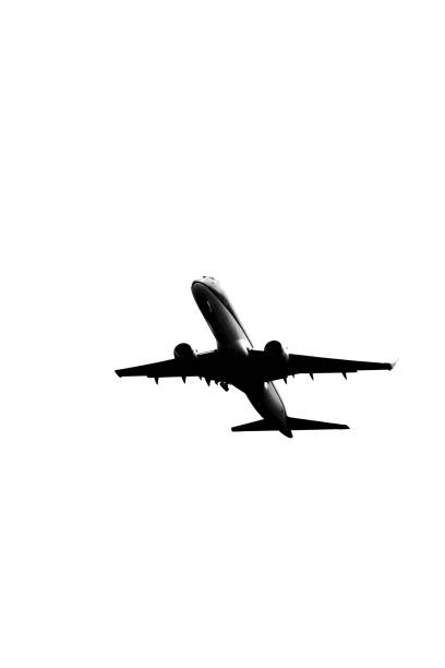 Silhouette of contemporary jetliner on the climbout after take-off from Airport, black and white image