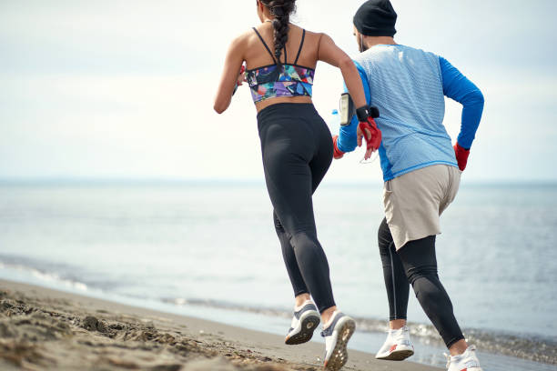 istock Young female boxer and her coach jogging on the beach 1276472538