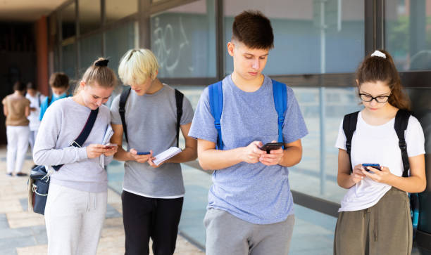 istock Interested teenagers using phones on college campus 1276478911
