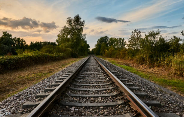 istock Old railway tracks running through rural countryside with beautiful sunset sky 1276478971