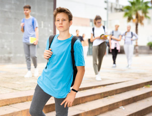 Positive teenager walking in the street; carrying bag on one shoulder Positive teenager walking in the street; carrying a bag on one shoulder 12 17 months stock pictures, royalty-free photos & images
