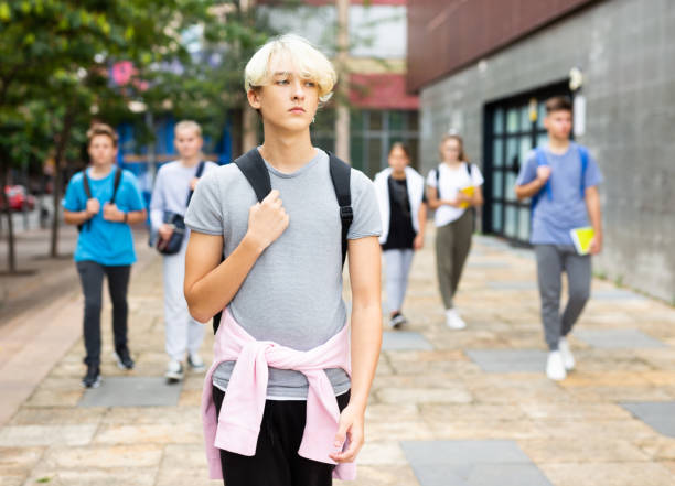 Positive teenager walking in the street; carrying bag on one shoulder Positive teenager walking in the street; carrying a bag on one shoulder 12 17 months stock pictures, royalty-free photos & images