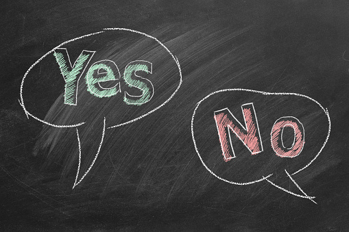 Speech bubbles with yes and no text written in chalk on a blackboard. Different points of view.