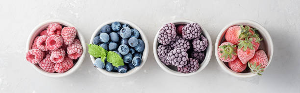 istock Frozen berries in small bowls against concrete background.Top view. 1276484357
