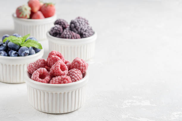 istock Frozen berries in small bowls on a concrete background from copies of space. 1276484365