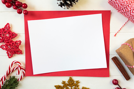 Top view of christmas decoration and blank card with copy space on white wooden table