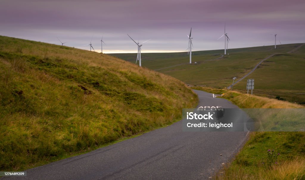Wind turbines in South Wales Wind turbines and a winding road on the Betws mountain in South Wales, UK Wind Turbine Stock Photo