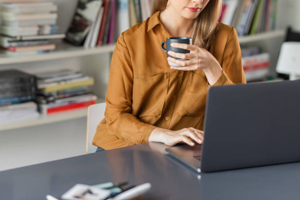 istock Businesswoman Wearing a Yellow Shirt Using a Laptop Computer 1276491119