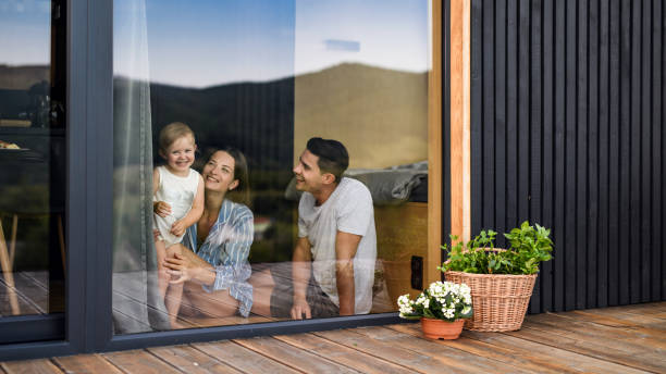 giovane famiglia con piccola figlia al chiuso, fine settimana di distanza in casa container in campagna. - family summer portrait nature foto e immagini stock