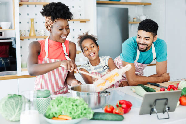 family child kitchen food daughter mother father cooking preparing breakfast  happy together Family preparing meal and having fun in the kitchen at home family dinners and cooking stock pictures, royalty-free photos & images