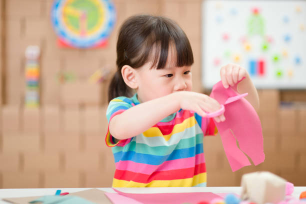 istock young girl using scissors cutting paper for making craft for home schooling 1276504600
