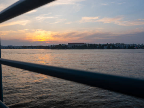 A beautiful sunset: View from the riverbank towards city skyline with calm waters on a summer night.