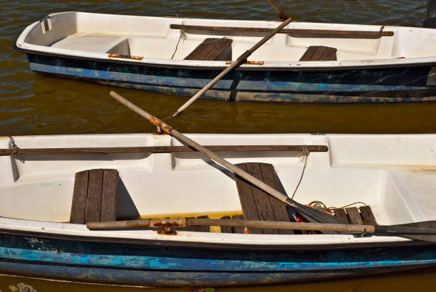 Old white boat on the lake near the pier.