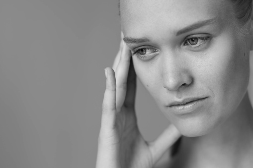 A woman holding her head in anxiety and frustration. Unhappy and depressed.