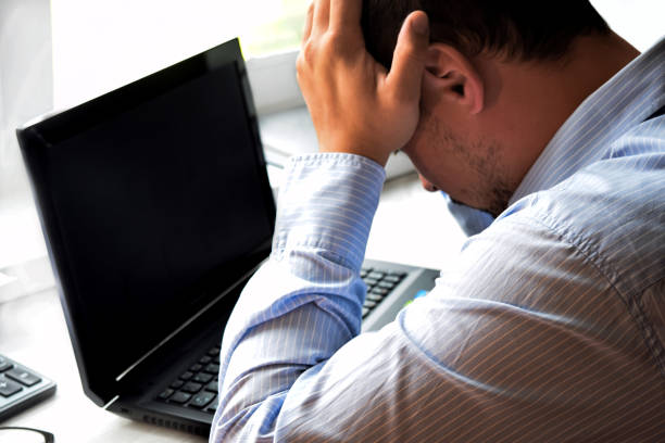 istock Businessman works in the office with laptop and documents on the table. Analyze plans, papers, keyboard hands. Blurred background, film effect. 1276510811