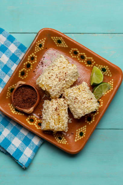 milho mexicano na espiga também chamado elotes com queijo e maionese em fundo turquesa - corn on the cob corn cooked boiled - fotografias e filmes do acervo