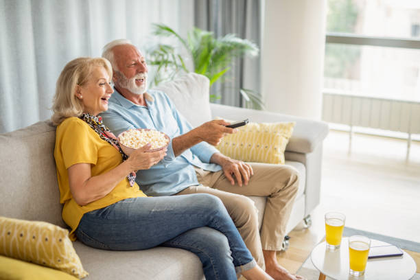 istock Senior husband and wife watching television together. 1276512669