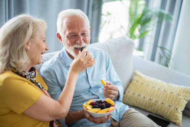 istock Senior couple eating a fruit salad together. 1276512678