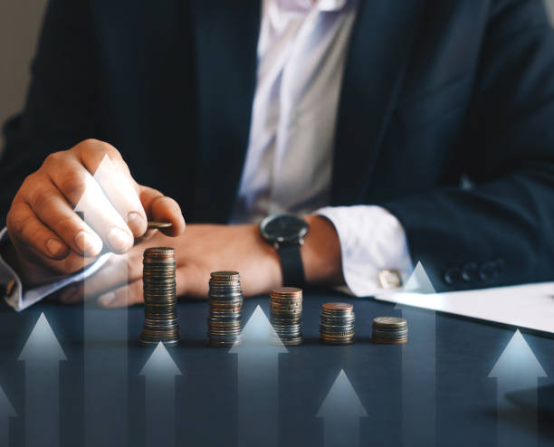 istock Businessman stacking coins with a graph of profit. 1276513870