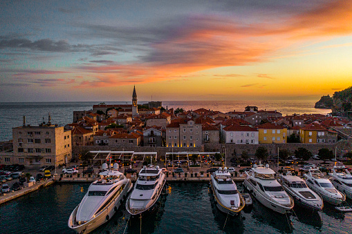 Incredible sunset over the historical part of Budva and marina with yachts at the Adriatic coast of Montenegro.