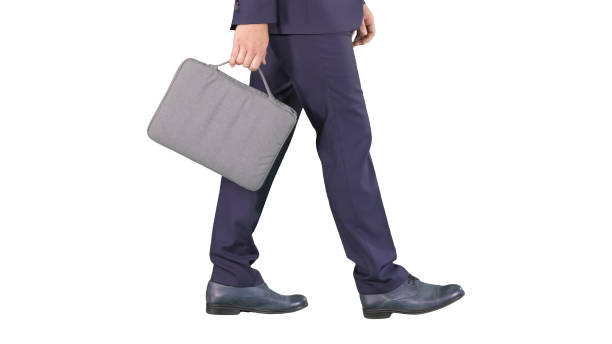 istock Handsome businessman in a suit walks with a briefcase on white background 1276515892