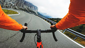 POV point of view racing bicycle riding on a road in the forest of Dolomites