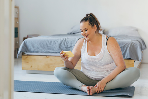 Happy  plus size woman exercising at home, weight loss concept.