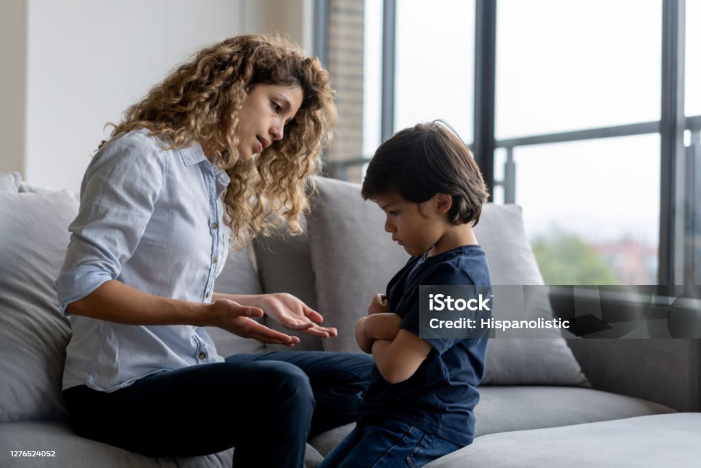 Boy having a tantrum at home and mother trying to talk to him Latin American boy at home having a tantrum at home and mother trying to talk to him - lifestyle concepts Child Stock Photo