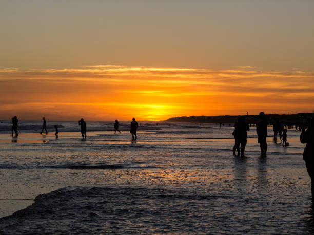 Silhouettes of people at the beach of Necochea, in the sunset