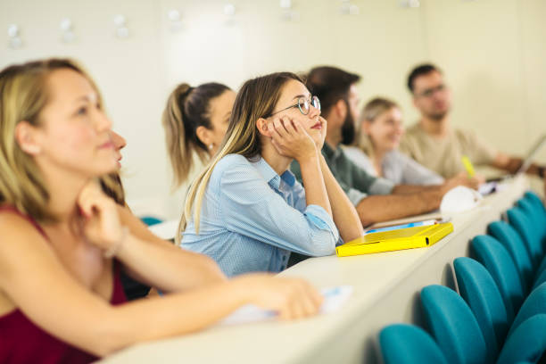 College students in classroom during COVID-19 College students wearing protection N95 mask due to covid19 pandemic and sitting in the classroom male college student sleeping through lecture stock pictures, royalty-free photos & images