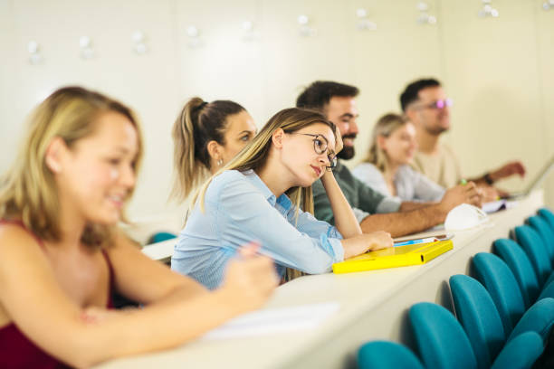 College students in classroom during COVID-19 College students wearing protection N95 mask due to covid19 pandemic and sitting in the classroom male college student sleeping through lecture stock pictures, royalty-free photos & images