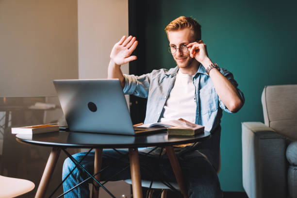 istock Young man college student in glasses studying distantly at home using video call 1276529787