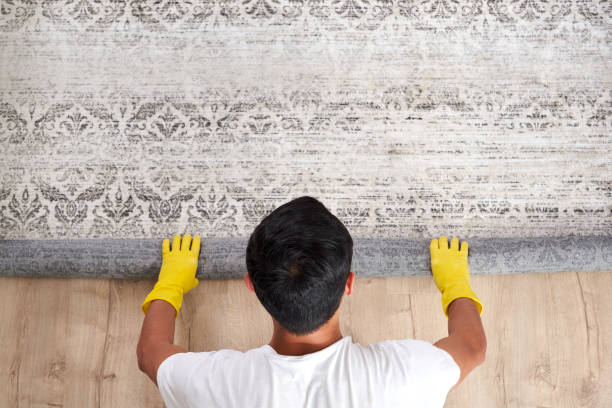 High angle view of man unrolling carpet. Cleaning service concept