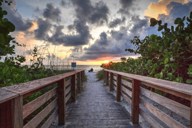 istock Lone man on a Boardwalk leading toward Delnor-Wiggins State Park at sunset 1276531799