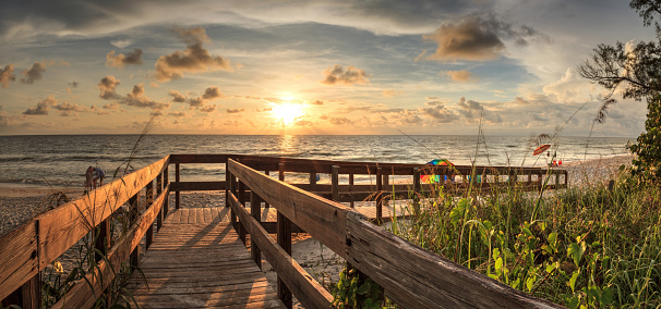 Boardwalk leading toward Delnor-Wiggins State Park at sunset in Naples, Florida.