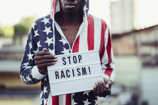 istock STOP RACISM concept. Man holding a sign agains racism 1276532987