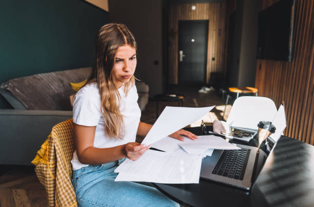 istock Woman calculating bills in the kitchen, sitting at table with laptop computer 1276533853