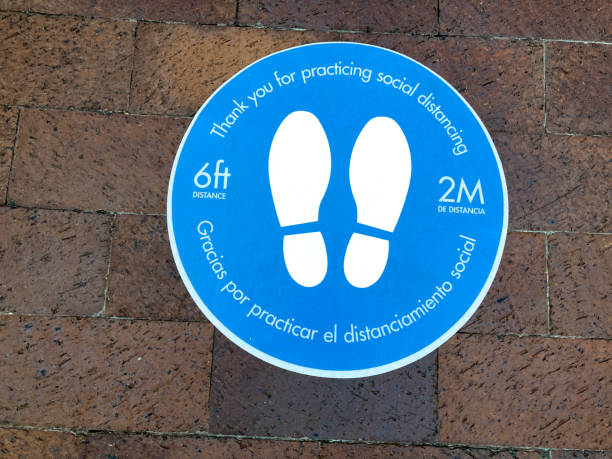 istock Bilingual Sign on Ground: Thank you for Practicing Social Distancing 1276534083